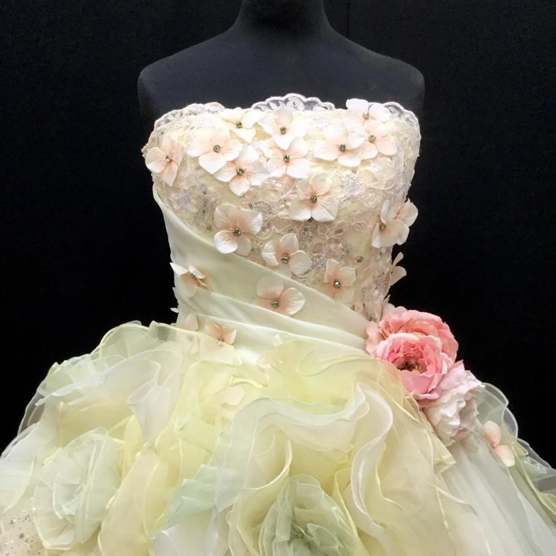 Light yellow strapless ball gown with a cinched waist and a voluminous puffy skirt; bridal gown R7287