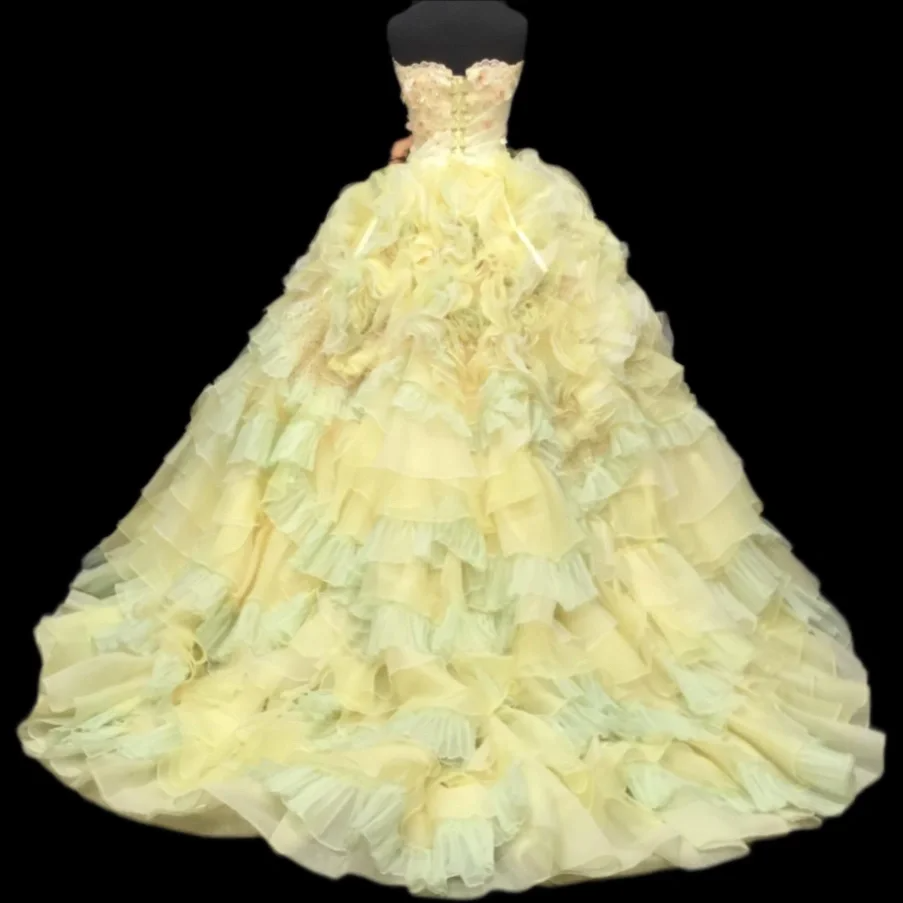 Light yellow strapless ball gown with a cinched waist and a voluminous puffy skirt; bridal gown R7287