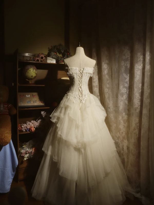 White strapless ball gown with a cinched waist and a voluminous tiered cake skirt; bridal gown R7289