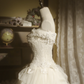 White strapless ball gown with a cinched waist and a voluminous tiered cake skirt; bridal gown R7289