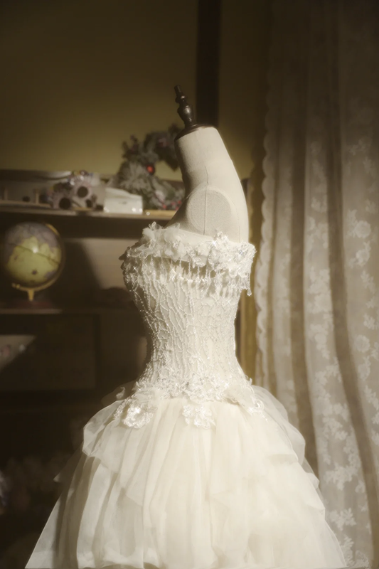 White strapless ball gown with a cinched waist and a voluminous tiered cake skirt; bridal gown R7289