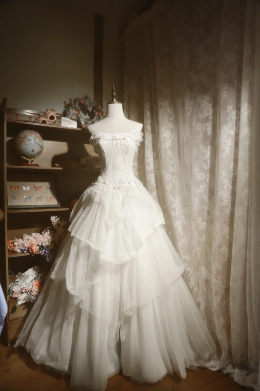 White strapless ball gown with a cinched waist and a voluminous tiered cake skirt; bridal gown R7289