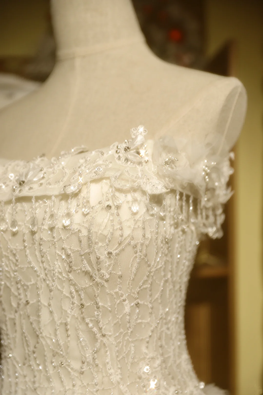 White strapless ball gown with a cinched waist and a voluminous tiered cake skirt; bridal gown R7289