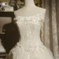 White strapless ball gown with a cinched waist and a voluminous tiered cake skirt; bridal gown R7289