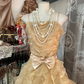 A gold, backless, fitted long dress with a multi-layered, voluminous skirt; a ball gown R6298