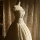 White off-the-shoulder floor-length ball gown with a cinched waist, slim fit and voluminous puffy skirt; bridal gown R7293