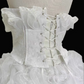 White strapless ball gown with a cinched waist and a voluminous tiered cake skirt; bridal gown R7300