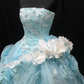 Light blue strapless ball gown with a cinched waist and a voluminous puffy skirt; bridal gown R7301