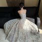Sheer white base with appliqué, strapless, waist‑cinched, slim‑fit, long ball gown with a voluminous ruffled skirt R8015