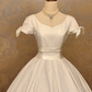 White square-neck floor-length ball gown with a cinched waist, slim fit and voluminous puffy skirt; bridal gown R7307