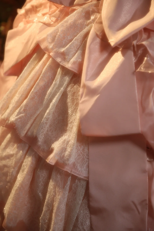 Pink strapless ball gown with a cinched waist and a voluminous tiered cake skirt; bridal gown R7282